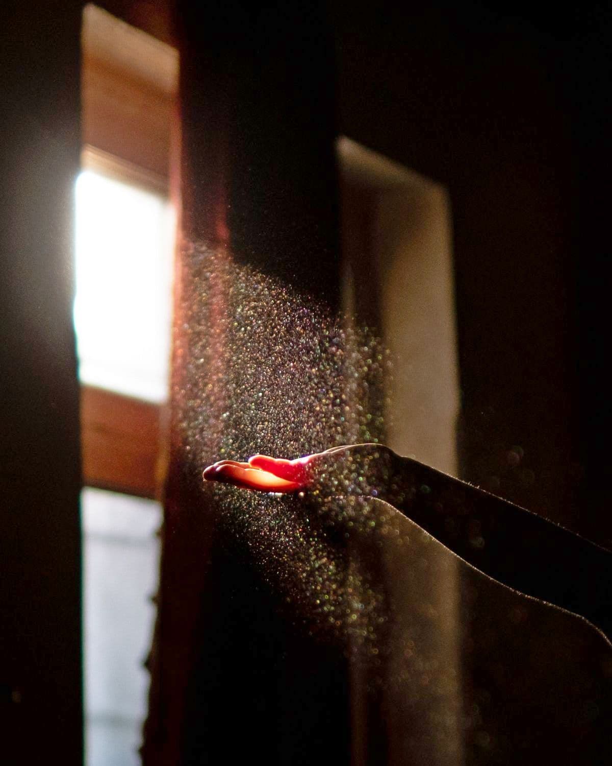 Dust floating in a sunbeam over an open hand